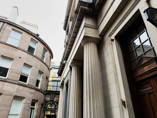 Obraz premium Classical stone columns and historic office entrance on a curved city street in Liverpool UK showcasing Georgian architecture and urban stone facades