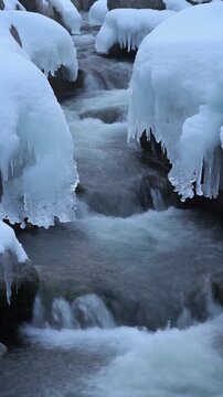 凍った岩の間を流れる水 シームレスループ動画背景 9:16 4K