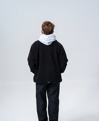 A young Asian man is wearing a black Sherpa fleece jacket, with a light gray hooded sweater underneath. © jeson
