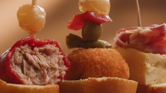 Tapas Spanish pinchos assortment, Basque pintxos with jamon iberico, tortilla, shrimp, stuffed piquillo pepper and egg on bread, traditional bar food close up