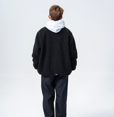 A young Asian man is wearing a black Sherpa fleece jacket, with a light gray hooded sweater underneath. © jeson