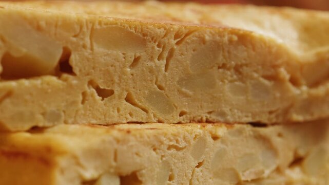 Spanish omelette tortilla, traditional potato and egg omelette sliced on wooden board, classic Spanish breakfast close up in cafe