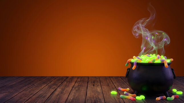 Black witch cauldron overflowing with glowing green candy and gummy worms with smoke on wooden table