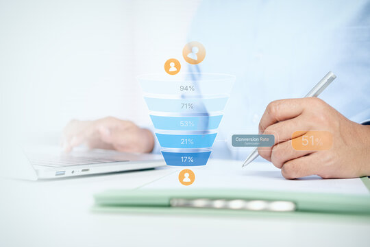 Businessman writing on document with digital marketing funnel and conversion rate optimization chart on white desk, concept of sales funnel, lead generation, and e-commerce strategy.