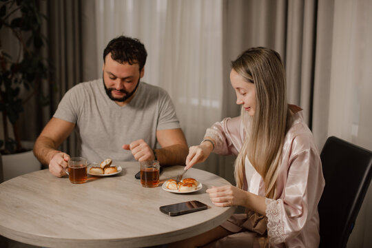 Young couple having breakfast at home together