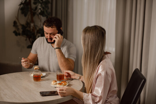 Man talking at home, having breakfast with woman at home