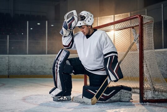 Tired Ice Hockey Goalie Resting by the Net After Game, Sports Fatigue, Mental Pressure, Recovery and Resilience Concept