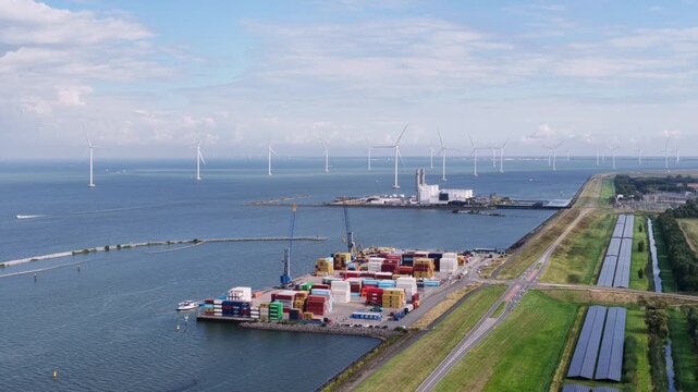 Aerial view of container terminal with industrial facilities and offshore wind turbines in the IJsselmeer near Lelystad, Flevoland, Netherlands.