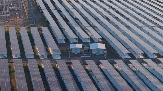 Aerial view of the PLTS Bali Timur solar farm featuring rows of photovoltaic panels and a small electrical substation in Kubu, Bali, Indonesia.