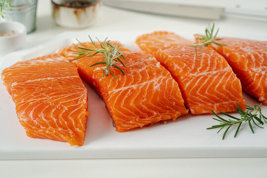 Salmon. Fresh raw salmon fish fillet with cooking ingredients, herbs and lemon on white background, top view