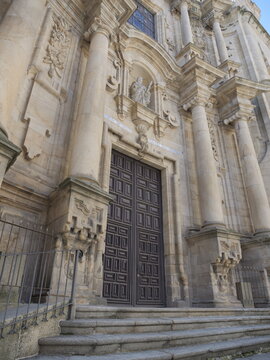 View of the ornate stone facade and grand wooden entrance doors of the Igrexa da Santa Eufemia in Ourense, Ourense, Spain.