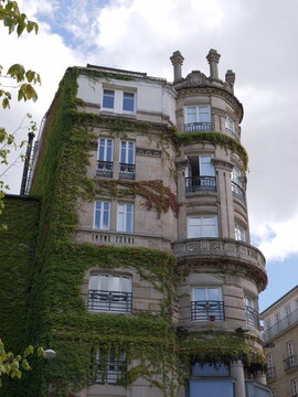 View of a historic stone building with ivy-covered walls and a rounded corner section featuring balconies in Ourense, Province of Ourense, Spain.