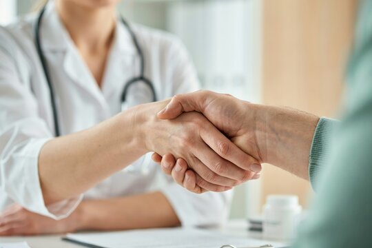 Doctor and patient shaking hands in medical office