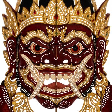 Close up face of Rahwana Wayang Kulit red demon king with fangs and golden crown isolated white