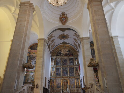 View of the ornate altar and vaulted interior of the Se de Portalegre cathedral with tall stone columns and gold carvings in Portalegre, Portalegre District, Portugal.