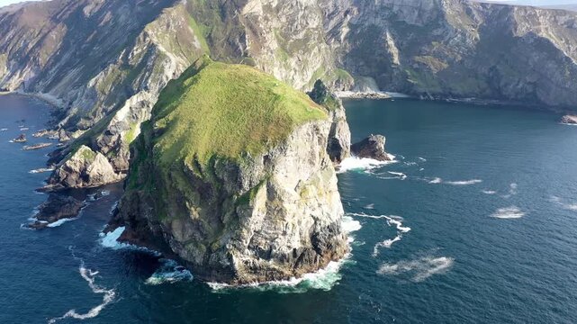 Aerial view of Tormore Island sea stack with rugged cliffs and Atlantic Ocean waves in Ardara, County Donegal, Ireland.