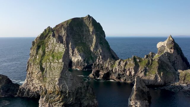 Aerial view of sea stacks at An Port, featuring rugged cliffs and deep blue Atlantic waters in Ardara, County Donegal, Ireland.