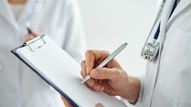 Doctor writing on a clipboard in a hospital setting