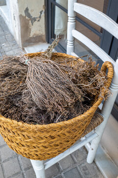 Woven basket with dried herbs on wooden chair