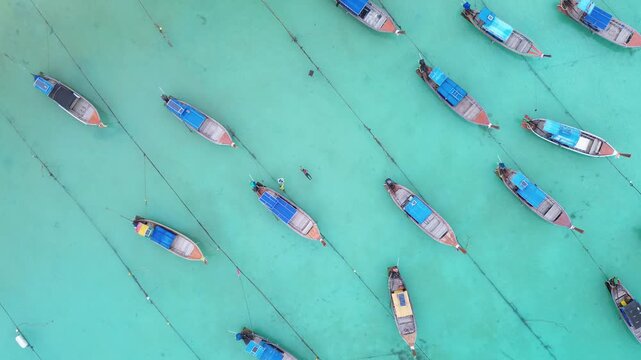 Aerial top down view of longtail boats in turquoise water