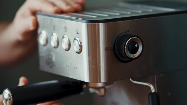 Person turning on espresso machine toggle switch to brew fresh coffee