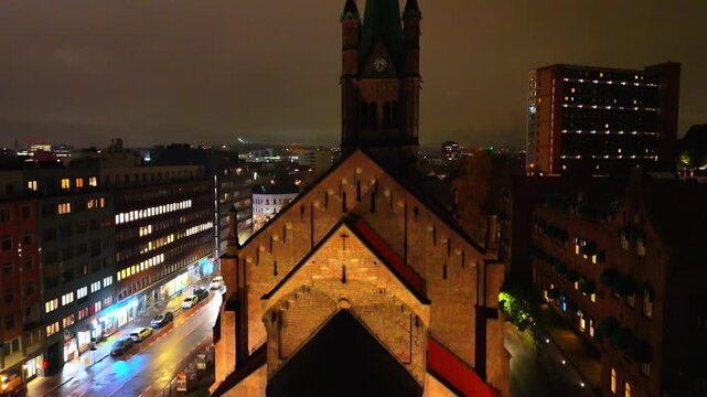 Drone aerial shot of illuminated apse of historic Gronland Church at night in Oslo, Norway
