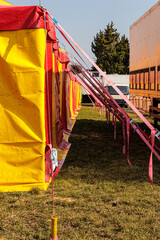 Colorful Red And Yellow Circus Tent Setup With Tension Straps At Outdoor Carnival Field © Olga