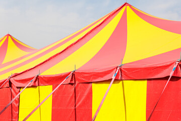 Red and Yellow Circus Tent Big Top at Outdoor Carnival Under Blue Sky © Olga