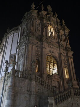 View of the illuminated baroque facade of the Clerigos Church with its intricate stone carvings and grand staircase at night in Porto, Porto District, Portugal.