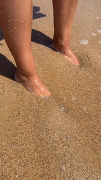 Bare feet standing at the beach shoreline