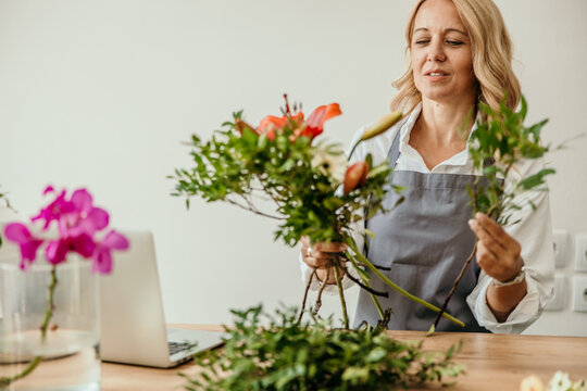 Female florist arranging flowers creating a bouquet