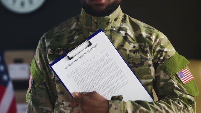 Black U.S. male soldier holds military employment contract for recruitment