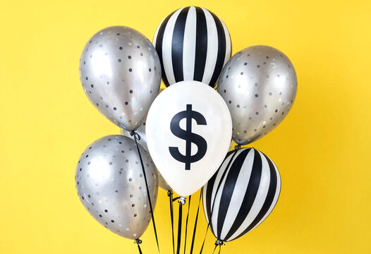Cluster of balloons featuring dollar sign and black white stripes on yellow background