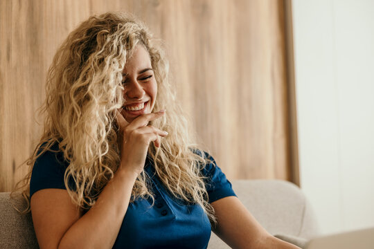 Happy young woman laughing indoors enjoying leisure time