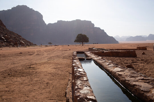 Precious water source and ancient irrigation channel in the arid desert of Wadi Rum, Jordan. Water scarcity and sustainability concept.
