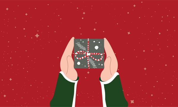 Hands in green sleeves holding a wrapped Christmas gift with candy-cane bow, winter foliage and falling snow on a festive red background, symbolizing holiday giving and joy
