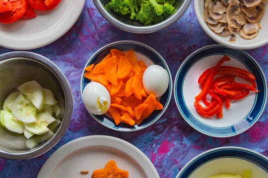 Vibrant vegetables arranged for fresh, healthy meals. Colorful carrots, peppers, and broccoli create visual appeal. Soft-boiled eggs and sliced cucumbers add texture and contrast