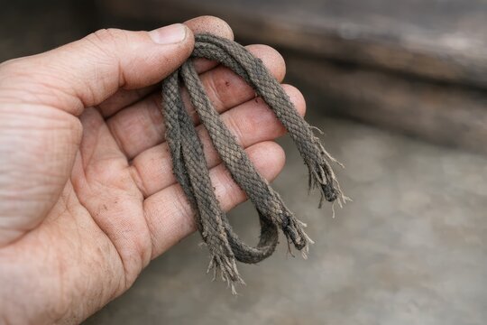 A person grasping a rope in their hand with a focused expression