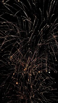 4K. loop seamless of real fireworks background golden shining fireworks with bokeh lights in the night sky. glowing fireworks show. New year's eve fireworks celebration multiple colors 