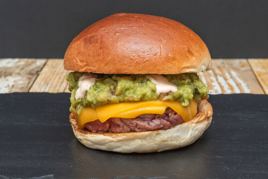 Guacamole Cheeseburger on Dark Slate, Glossy Bun Front and Center