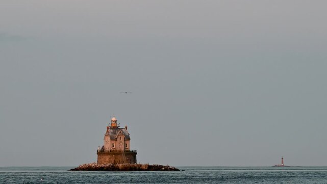 Fishers Island, New York, USA - Birds Flying Over Race Rock Lighthouse in Quiet Daytime Seascape