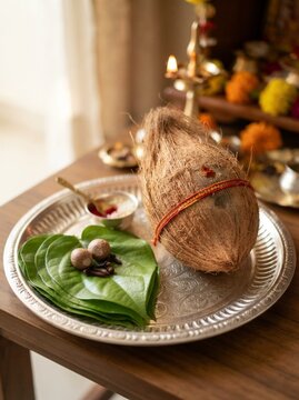Sacred coconut and fresh betel leaves arranged for Hindu puja ritual