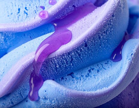 Blue and purple ice cream swirl with glossy purple syrup drizzle in macro shot
