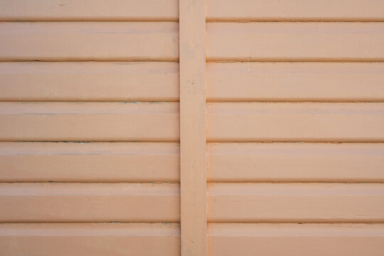 Pale peach painted horizontal wooden boards with vertical batten