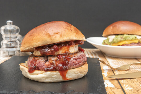 Brie and Berry Jam Burger with Guacamole Burger and Cutlery in Background