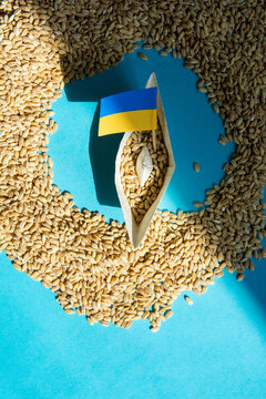 Ukrainian Grain Export Blockade and Food Crisis Concept with Paper Boat and Flag on Wheat Seeds Background