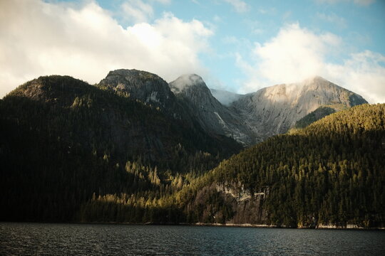 Forested mountains and a dark lake with shoreline buildings