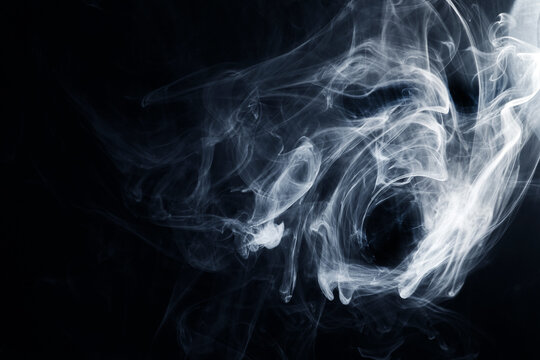 White smoke swirling against dark black background