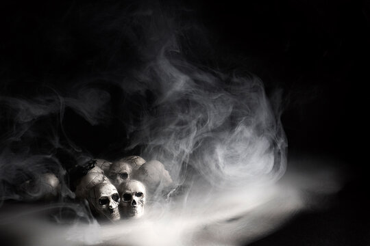 Human skulls emerging from mysterious smoky fog