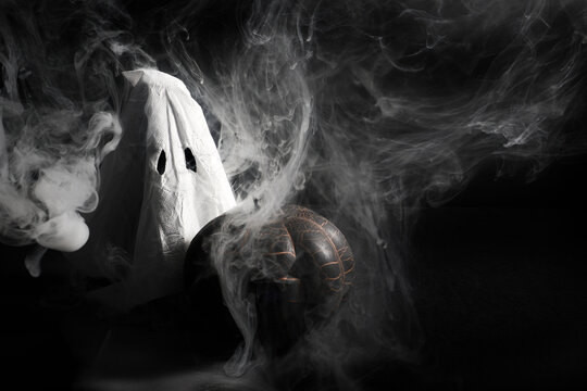Ghost figure and pumpkin surrounded by swirling smoke